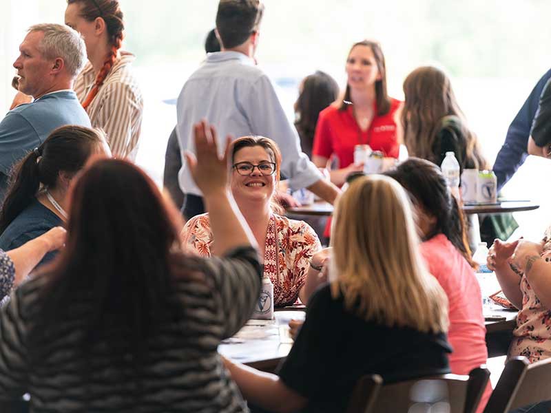 group of people sitting around a table smiling